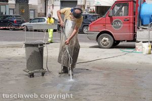 Viterbo - Operai al lavoro per togliere le strisce nere da Piazza Fontana Grande