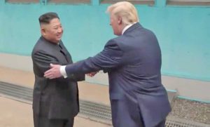 La stretta di mano tra Trump e Kim