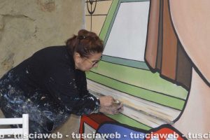 L'artista Tina loiodice a lavoro sul murale