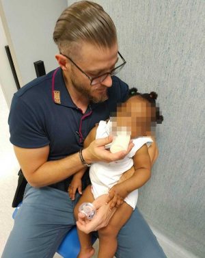 Napoli - Poliziotto si prende cura di una bimba