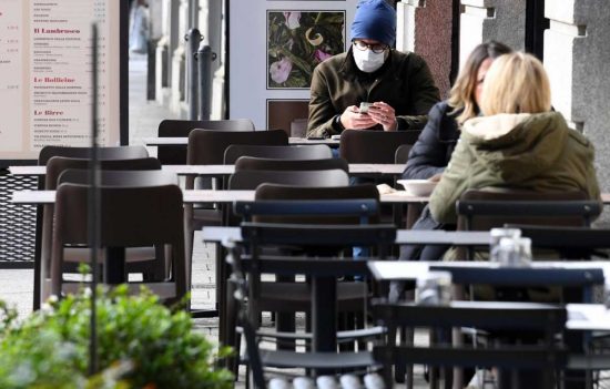 Covid - Persone sedute ai tavoli di un bar
