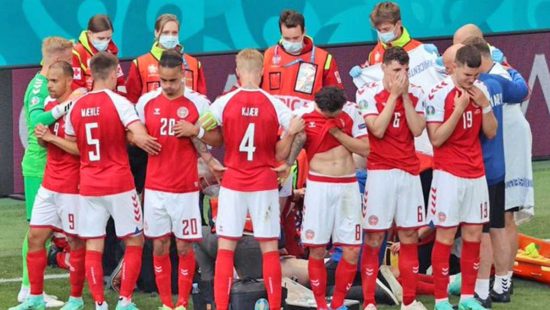 I giocatori della Danimarca formano un cordone intorno a Eriksen a terra per proteggerlo dagli sguardi del pubblico