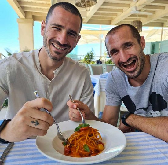 Bonucci e Chiellini di fronte a un piatto di pasta 