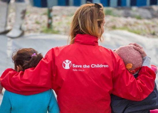 Bambini con un’operatrice di Save the children