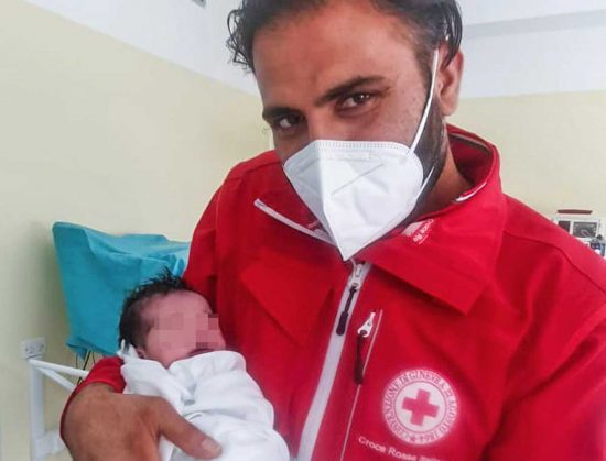 La piccola Hina in braccio a un operatore della Croce rossa