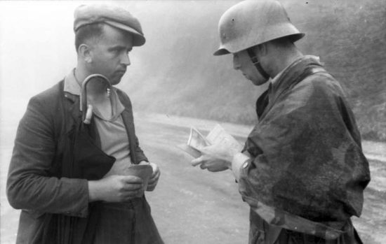 Un soldato tedesco controlla i documenti di un civile durante la seconda guerra mondiale