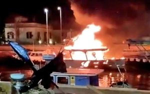 Roma - Peschereccio in fiamme nel canale di Fiumicino