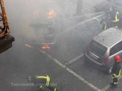 I vigili del fuoco spengono l\'auto in fiamme
