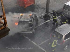 I vigili del fuoco spengono l\'auto in fiamme