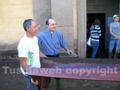 Don Mario Zanasi a lavoro per spalare il fango
