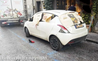 La macchina della sindaca Chiara Frontini con i giornali e vicino un paio di scarpe a spillo e un paio di mutandine rosse