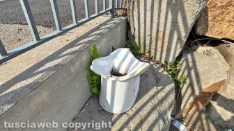 Viterbo - Il "mezzo water" abbandonato in un angolo del parcheggio delle Fortezze, sullo sfondo le mura e le torri medievali della città