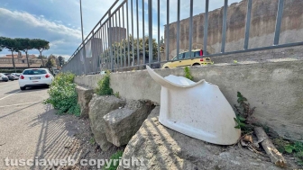 Viterbo - Il "mezzo water" abbandonato in un angolo del parcheggio delle Fortezze, sullo sfondo le mura e le torri medievali della città