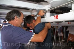 Un anziano facchino spiega a un giovane come si porta la Macchina