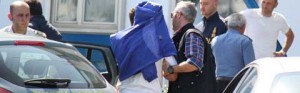 Al centro, coperto, uno degli arrestati