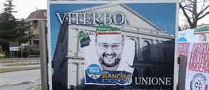 Il manifesto elettorale sul cartello di benvenuto della città