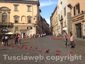 Piazza del Comune divisa tra auto d'epoca e scarpe rosse