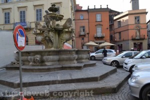 La fontana di piazza delle Erbe assediata dalle auto