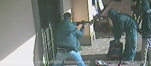 I tre malviventi ripresi mentre sfondano la porta a mazzate