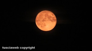 La super luna attraversata da un aereo