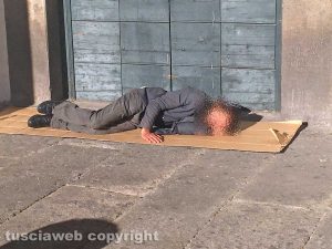 Viterbo - Piazza del Comune - Un uomo dorme sotto ai portici