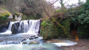 La cascata del castello di Chia con i ruderi di un mulino