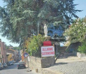 Marta - Il cartello Allarme satanismo sotto la statua della Madonna