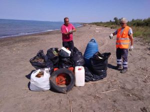 Gli operai raccolgono rifiuti in spiaggia