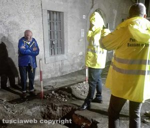 Bassano in Teverina - Il sindaco Romoli (con l'impermeabile giallo) al lavoro sulla tubatura ostruita