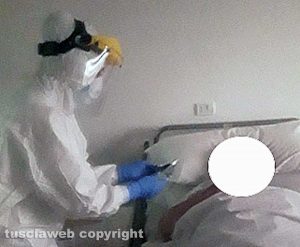 Un operatore delle Croce rossa mentre mette in comunicazione visiva con i parenti una anziana di Villa Noemi