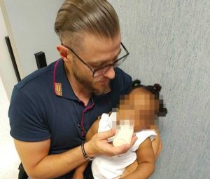 Napoli - Poliziotto si prende cura di una bimba