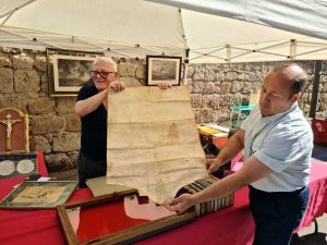 L'espositore Antonio Di Martino e il vicesindaco di Bagnoregio Claudio Cavalloro mostrano una pergamena antica