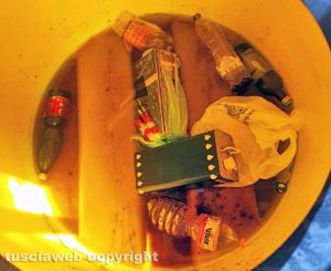 Bottiglie e lattine dei metallo all'interno del contenitore degli oli esausti