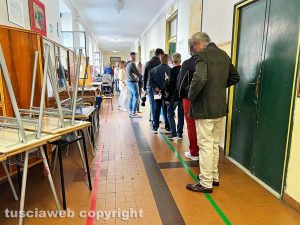 Elezioni politiche - Una fila di uomini e una di donne (in fondo) al seggio della Fantappié