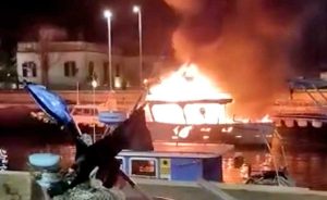 Roma - Peschereccio in fiamme nel canale di Fiumicino