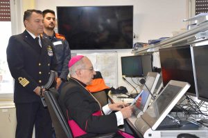 Civitavecchia - Il vescovo Gianrico Ruzza benedice la comunità portuale dalla sala operativa della guardia costiera