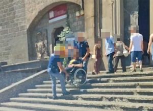 Viterbo - Poliziotti aiutano una signora in carrozzina a scendere le scale del duomo