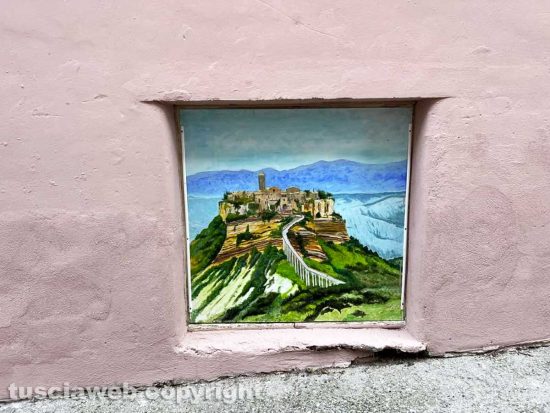 Viterbo - Il muro all'uscita dall'ascensore che porta al duomo pitturato in rosa con tanto di murali e un cartello pubblicitario