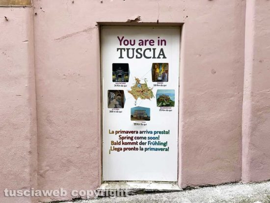 Viterbo - Il muro all'uscita dall'ascensore che porta al duomo pitturato in rosa con tanto di murali e il cartello pubblicitario senza i loghi, cancellati da Giulio Della Rocca