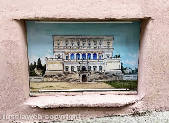 Viterbo - Il muro all'uscita dall'ascensore che porta al duomo pitturato in rosa con tanto di murali e un cartello pubblicitario