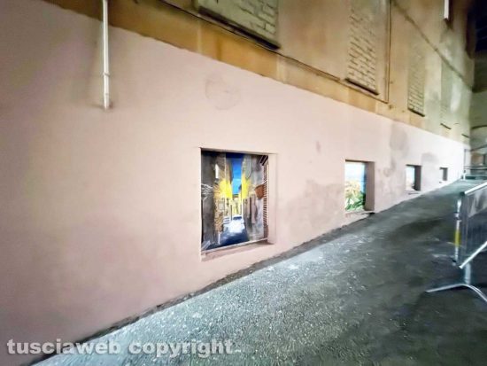 Viterbo - Il muro all'uscita dall'ascensore che porta al duomo pitturato in rosa con tanto di murali e un cartello pubblicitario