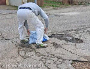 San Martino al Cimino - Un residente poggia del bitume sulle buche in via Di Vittorio