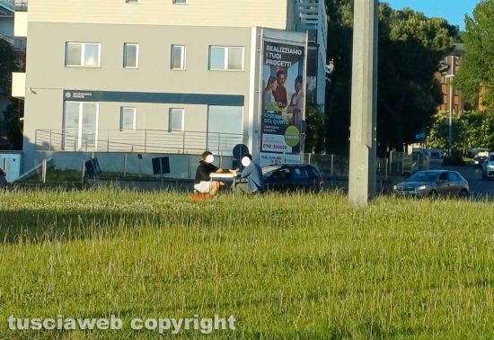 Viterbo - Due ragazzi fanno il pic-nic sulla rotonda dell'Ipercoop