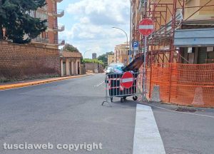 Viterbo - Via della Pila, una transenna fermata da un cassonetto pieno di rifiuti