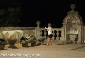 Viterbo - Donna fa il bucato nella fontana di palazzo dei Priori e stende i panni sui sarcofagi