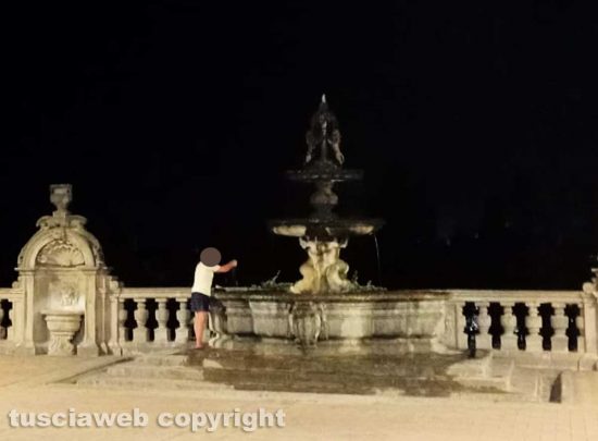 Viterbo - Donna fa il bucato nella fontana di palazzo dei Priori e stende i panni sui sarcofagi