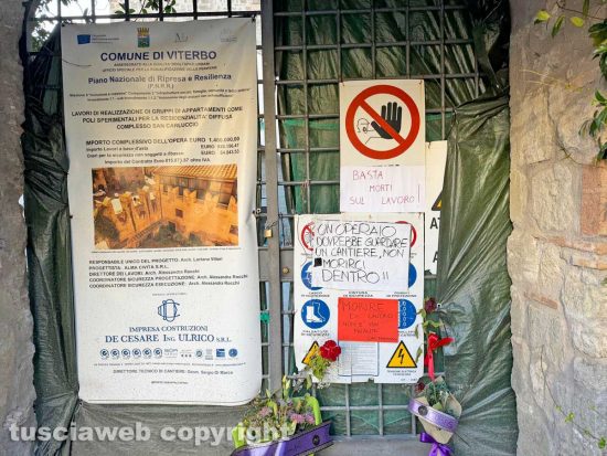 Viterbo – Fiori e cartelli sul cancello del cantiere di piazza San Carluccio dove è morto un operaio